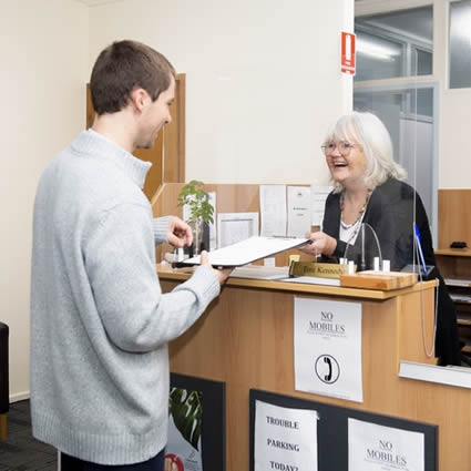 A patient claiming a private health rebate through HICAPS at a Canberra chiropractic clinic reception